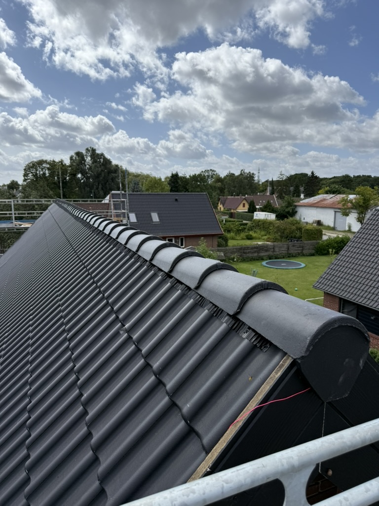 Mørke betontagsten på sadeltag set fra rygningen under montering