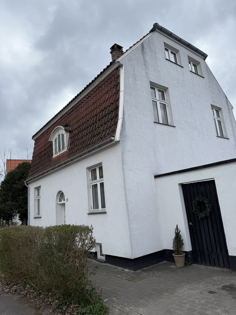 Tegltag på hvid mansardvilla med kvist og garage